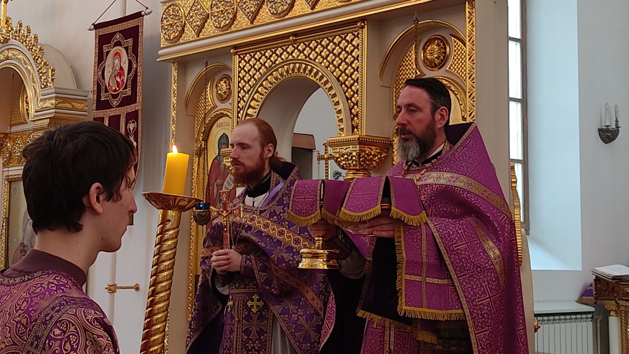 Священники Дмитрий Попов и Кирилл Краснощеков в фиолетовых одеяниях и с Чашей в руках