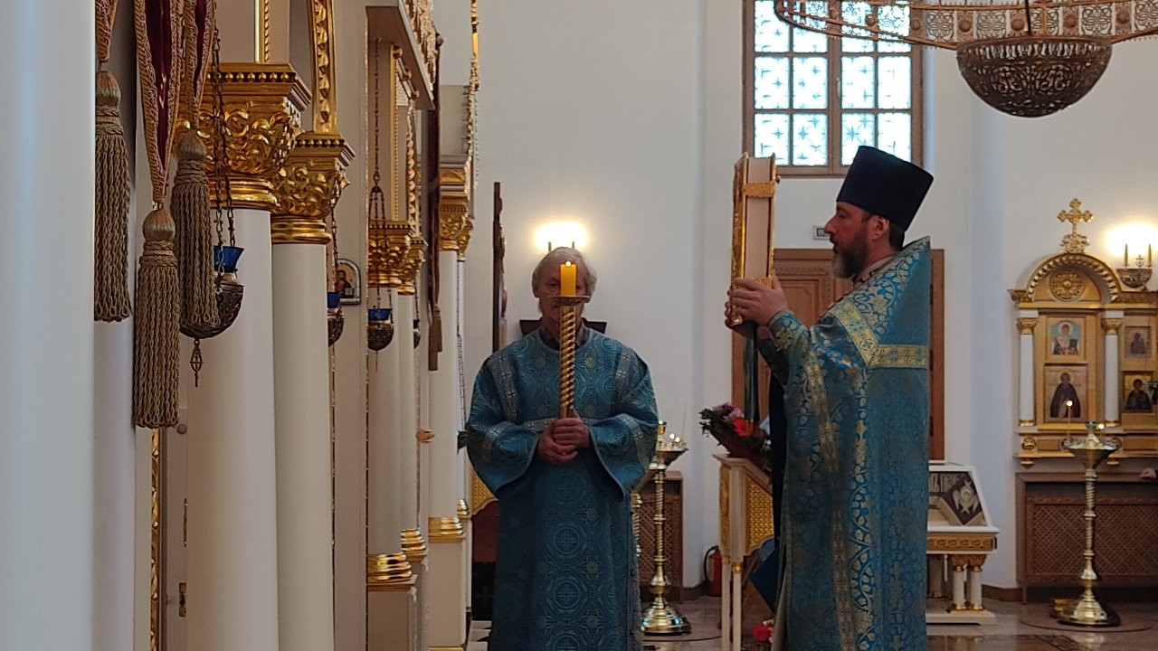 Священник в голубом одеянии с Апостолом в руках на солее