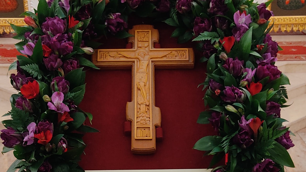 Крест Господень в крестопоклонную неделю в храме Мефодия и Кирилла, Саратов, 2022. Крест на темно-красном полотне в окружении красно-фиолетовых цветов